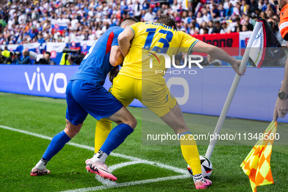 Robert Bozenik of Slovakia is confronting Ilya Zabarnyi of Ukraine (L-R)  during the UEFA EURO 2024 group stage match between Slovakia and U...