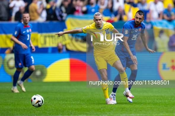 Mykhailo Mudryk of Ukraine is playing against Ivan Schranz of Slovakia (L-R)  during the UEFA EURO 2024 group stage match between Slovakia a...