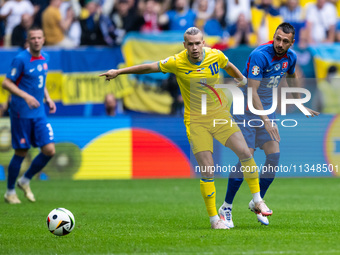 Mykhailo Mudryk of Ukraine is playing against Ivan Schranz of Slovakia (L-R)  during the UEFA EURO 2024 group stage match between Slovakia a...