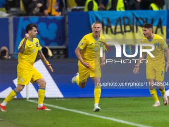 Mykola Shaparenko (L) of Ukraine is celebrating after scoring his team's first goal with Oleksandr Zinchenko (C) and Georgiy Sudakov (R) of...