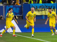 Mykola Shaparenko (L) of Ukraine is celebrating after scoring his team's first goal with Oleksandr Zinchenko (C) and Georgiy Sudakov (R) of...