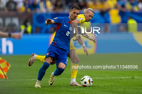 Peter Pekarik of Slovakia is battling for possession with Mykhailo Mudryk of Ukraine  during the UEFA EURO 2024 group stage match between Sl...