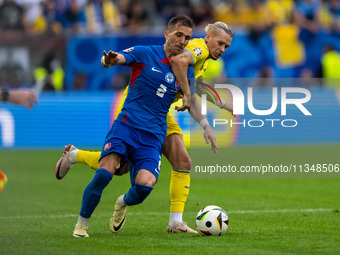 Peter Pekarik of Slovakia is battling for possession with Mykhailo Mudryk of Ukraine  during the UEFA EURO 2024 group stage match between Sl...