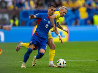 Peter Pekarik of Slovakia is battling for possession with Mykhailo Mudryk of Ukraine  during the UEFA EURO 2024 group stage match between Sl...