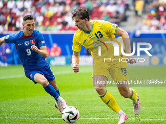 Robert Bozenik of Slovakia is confronting Ilya Zabarnyi of Ukraine (L-R)  during the UEFA EURO 2024 group stage match between Slovakia and U...