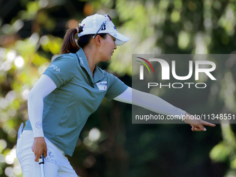 Jin Young Ko of Republic of Korea communicates with her caddie as she prepares to putt on the 9th green during the first round of the KPMG W...