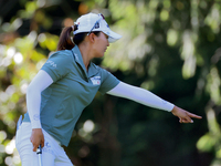 Jin Young Ko of Republic of Korea communicates with her caddie as she prepares to putt on the 9th green during the first round of the KPMG W...