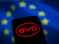 Chinese EV maker BYD logo is seen in a mobile device screen in this illsutration photo with Chinese and EU flags in the background in Warsaw...