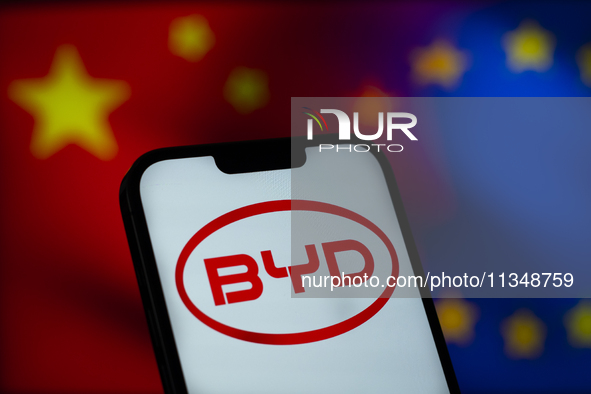 Chinese EV maker BYD logo is seen in a mobile device screen in this illsutration photo with Chinese and EU flags in the background in Warsaw...