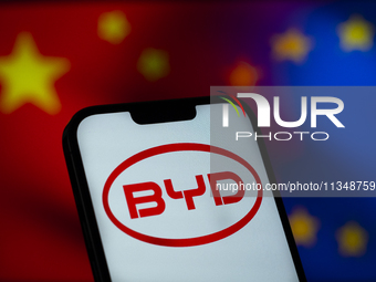 Chinese EV maker BYD logo is seen in a mobile device screen in this illsutration photo with Chinese and EU flags in the background in Warsaw...