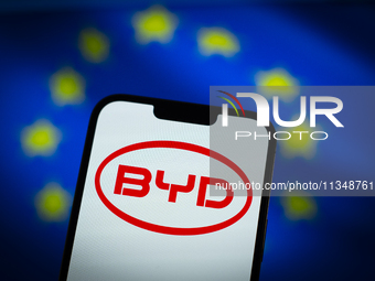 Chinese EV maker BYD logo is seen in a mobile device screen in this illsutration photo with Chinese and EU flags in the background in Warsaw...