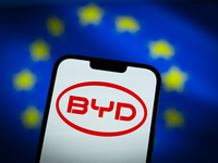 Chinese EV maker BYD logo is seen in a mobile device screen in this illsutration photo with Chinese and EU flags in the background in Warsaw...