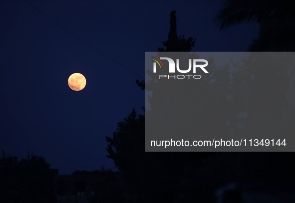 The full moon is rising over Deir al-Balah in the central Gaza Strip, on June 21, 2024, as the conflict is continuing in the Palestinian ter...