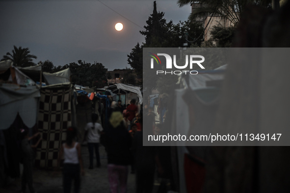 The full moon is rising over Deir al-Balah in the central Gaza Strip, on June 21, 2024, as the conflict is continuing in the Palestinian ter...