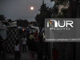 The full moon is rising over Deir al-Balah in the central Gaza Strip, on June 21, 2024, as the conflict is continuing in the Palestinian ter...