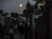 The full moon is rising over Deir al-Balah in the central Gaza Strip, on June 21, 2024, as the conflict is continuing in the Palestinian ter...