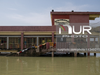 Local residents are gathering at a school building after floodwaters are inundating their homes in Gowainghat, Sylhet, Bangladesh, on June 2...