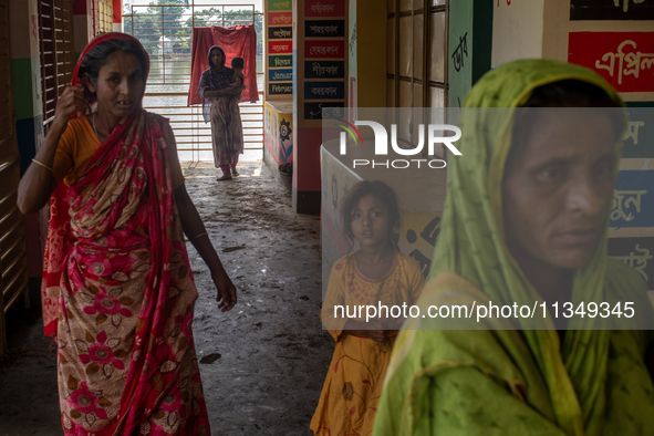 Local residents are gathering at a school building after floodwaters are inundating their homes in Gowainghat, Sylhet, Bangladesh, on June 2...