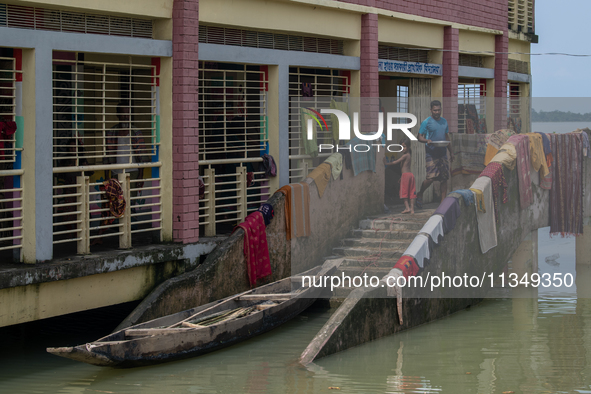 Local residents are gathering at a school building after floodwaters are inundating their homes in Gowainghat, Sylhet, Bangladesh, on June 2...