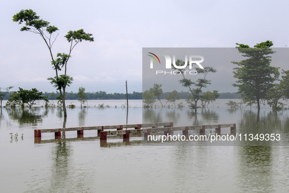 A partially submerged bridge is being seen after a flood in Gowainghat, Sylhet, Bangladesh, on June 21, 2024. 