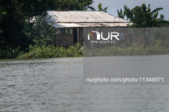 A man is sitting in his house after a flood in Gowainghat, Sylhet, Bangladesh, on June 21, 2024. 