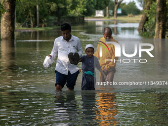 People are wading through floodwater in Gowainghat, Sylhet, Bangladesh, on Friday, June 21, 2024. (