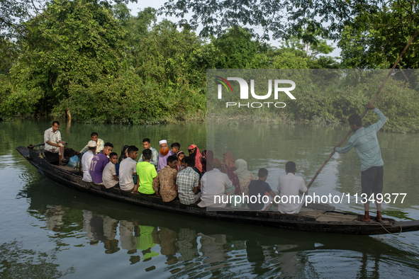 People are rowing a boat through floodwater after a flood in Gowainghat, Sylhet, Bangladesh, on June 21, 2024. 