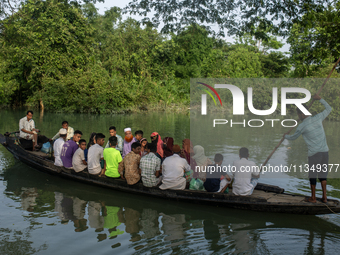 People are rowing a boat through floodwater after a flood in Gowainghat, Sylhet, Bangladesh, on June 21, 2024. (