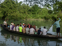 People are rowing a boat through floodwater after a flood in Gowainghat, Sylhet, Bangladesh, on June 21, 2024. (