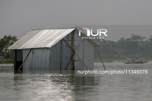 A house is being seen partially submerged after a flood in Gowainghat, Sylhet, Bangladesh, on Friday, June 21, 2024. 