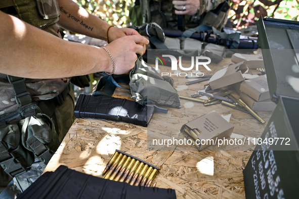 A soldier of a reconnaissance unit of the 128th separate mountain assault brigade of the Zakarpattia region is getting ready for a firearms...