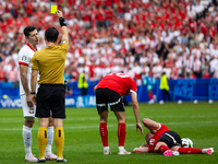 Referee Umut Meler  is showing  a yellow card to Robert Lewandowski  during the UEFA Euro 2024 Group D match between Poland v Austria, at th...