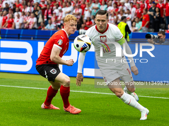 Nicolas Seiwald, Piotr Zielinski are playing during the UEFA Euro 2024 Group D match between Poland v Austria, at the Olympiastadion in Berl...