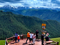 Tourists are enjoying snow-capped mountains, forests, and grasslands at the grassland section of Qilian Mountain National Park in Zhangye ci...