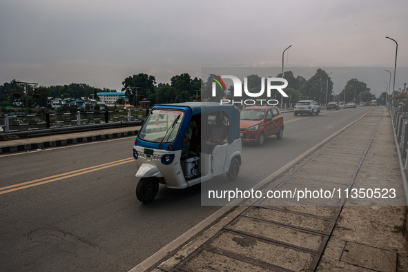 An E-Rickshaw is moving on a highway in Srinagar, Jammu and Kashmir, India, on June 22, 2024. 