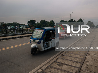 An E-Rickshaw is moving on a highway in Srinagar, Jammu and Kashmir, India, on June 22, 2024. (