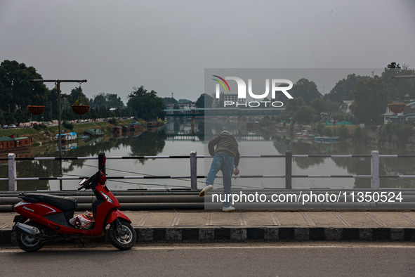 A man is throwing a garbage bag in river Jhelum in Srinagar, Jammu and Kashmir, India, on June 22, 2024. 