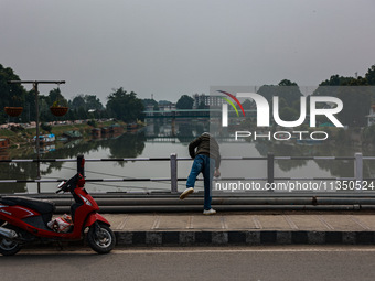 A man is throwing a garbage bag in river Jhelum in Srinagar, Jammu and Kashmir, India, on June 22, 2024. (