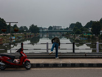 A man is throwing a garbage bag in river Jhelum in Srinagar, Jammu and Kashmir, India, on June 22, 2024. (