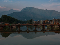 People are walking on Zero Bridge in Rajbagh on a cloudy day in Srinagar, Jammu and Kashmir, India, on June 22, 2024 (