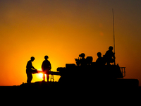 Officers and soldiers are preparing vehicles before maneuvering during a live-fire tactical drill in Jiuquan, Gansu province, China, on June...