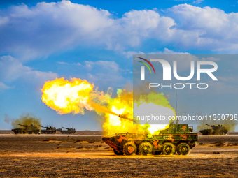 A howitzer unit is striking a target during a live-fire tactical drill in Jiuquan, Gansu province, China, on June 20, 2024. (