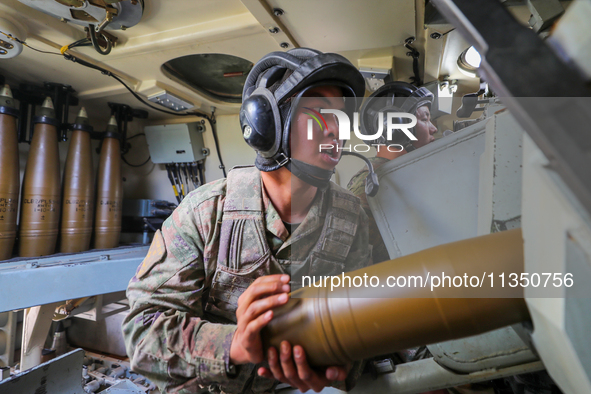 A Chinese soldier is loading ammunition during a live-fire tactical drill in Jiuquan, Gansu province, China, on June 20, 2024. 