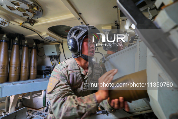 A Chinese soldier is loading ammunition during a live-fire tactical drill in Jiuquan, Gansu province, China, on June 20, 2024. 