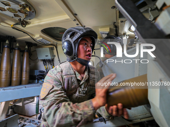 A Chinese soldier is loading ammunition during a live-fire tactical drill in Jiuquan, Gansu province, China, on June 20, 2024. (