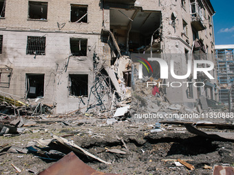 An impact pit and a partially destroyed residential building are being shown, in Kharkiv, on  June 22, 2024.  (