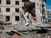 An impact pit and a partially destroyed residential building are being shown, in Kharkiv, on  June 22, 2024.  (