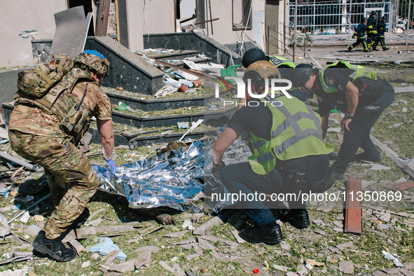 The police are covering the body of one of the dead  in Kharkiv, on  June 22, 2024.  