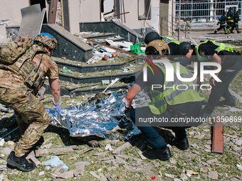 The police are covering the body of one of the dead  in Kharkiv, on  June 22, 2024.  (