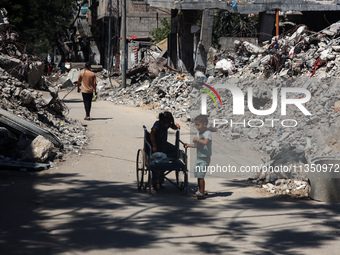 Palestinians are making their way past destroyed buildings in al-Bureij refugee camp in the central Gaza Strip, on June 22, 2024, amid the o...